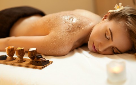 a woman enjoying a sugar scrub in the spa 